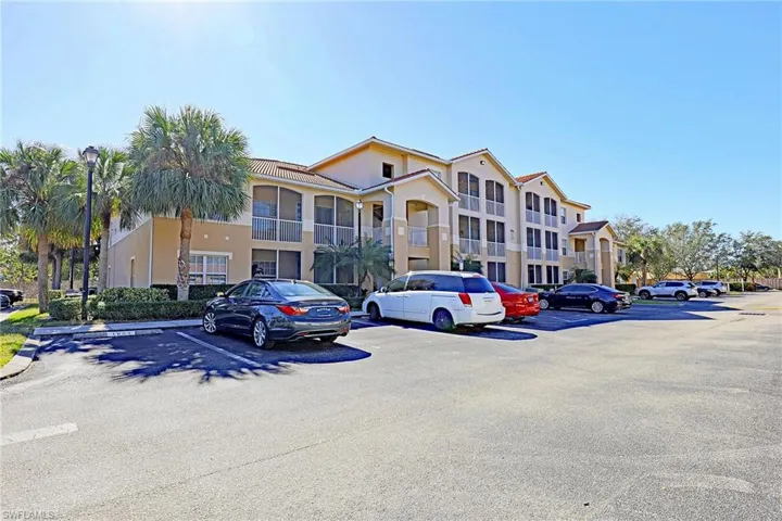 View of apartment building / complex with uncovered parking