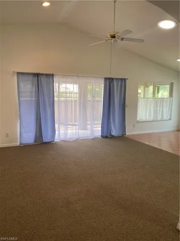 Carpeted Living room featuring lofted ceiling and ceiling fan