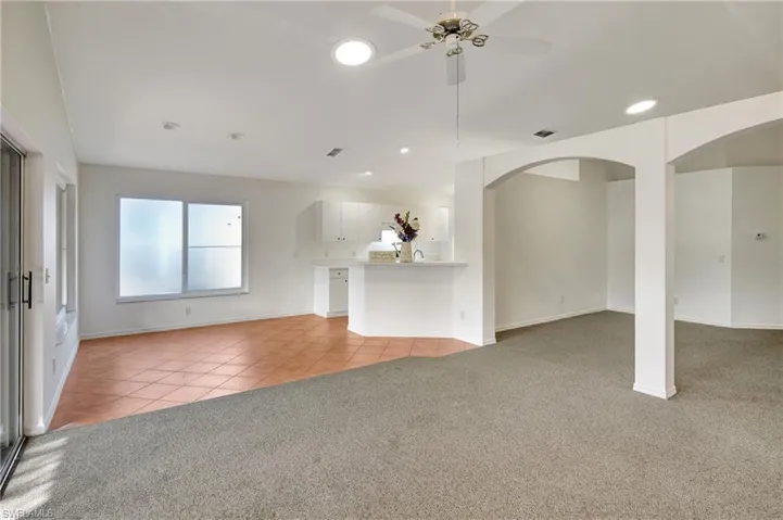 Open concept view of living area and kitchen. Dining area hurricane impact windows.