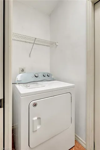 Dryer located indoors with upper shelf for storage.