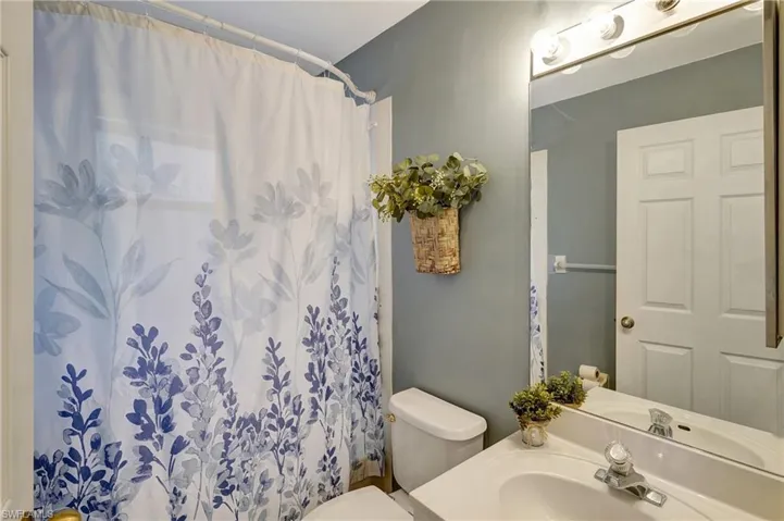 Guest Bathroom with a tub. Window in the bathroom has hurricane covers.