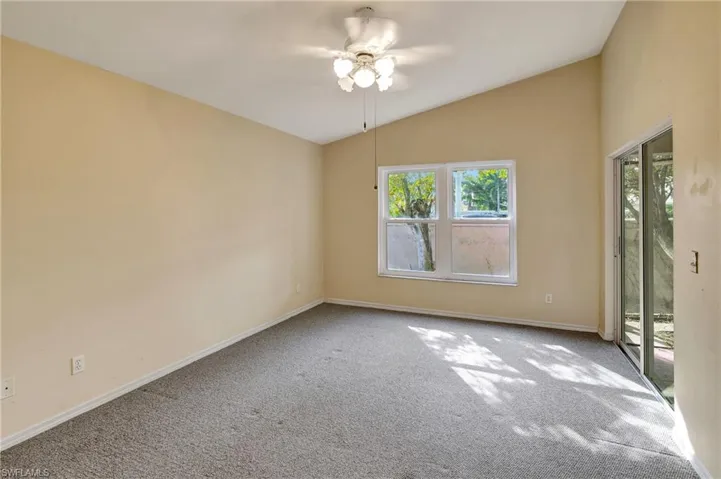Master Bedroom with view of back of the house and lanai access. Hurricane impact window.