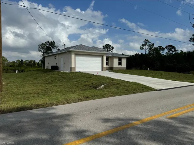 View of front of house featuring a front lawn and a garage