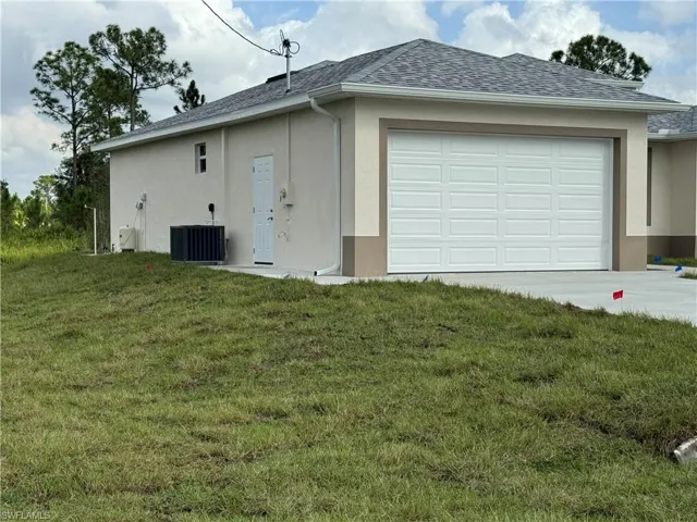 Garage featuring a lawn and cooling unit