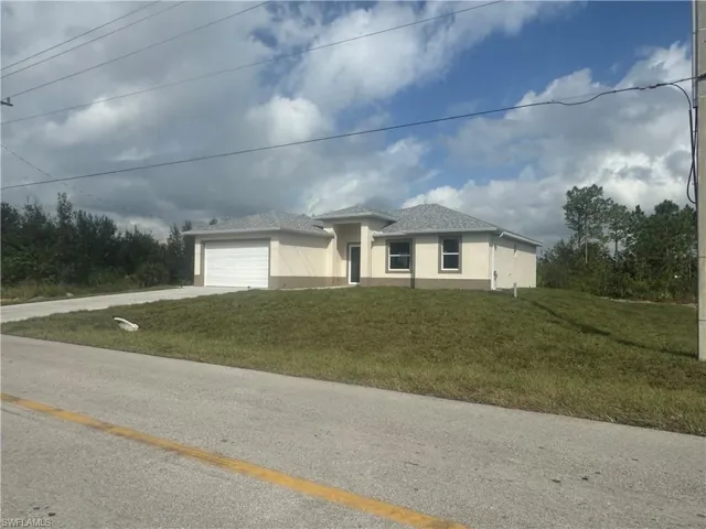 View of front facade with a front yard and a garage