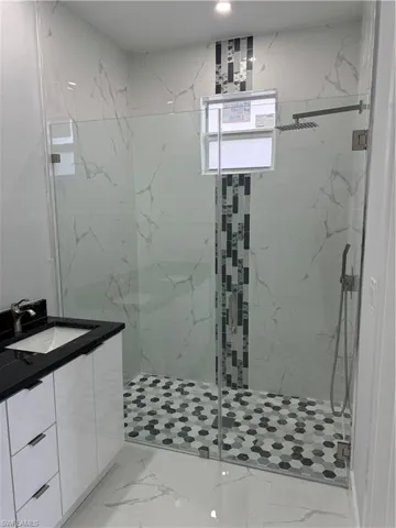 Bathroom with vanity and a shower with shower door