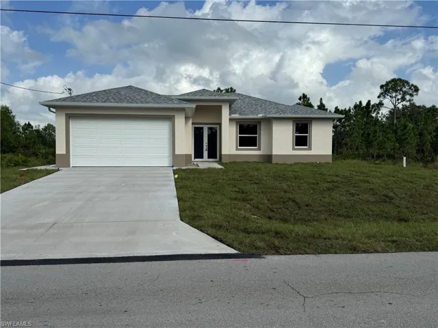 View of front of property featuring a front lawn and a garage
