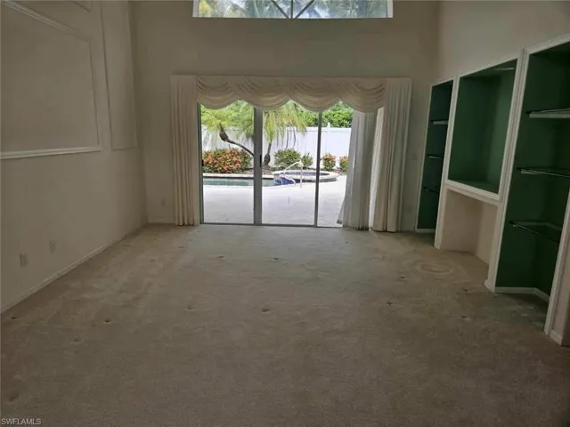 Carpeted empty room with a high ceiling