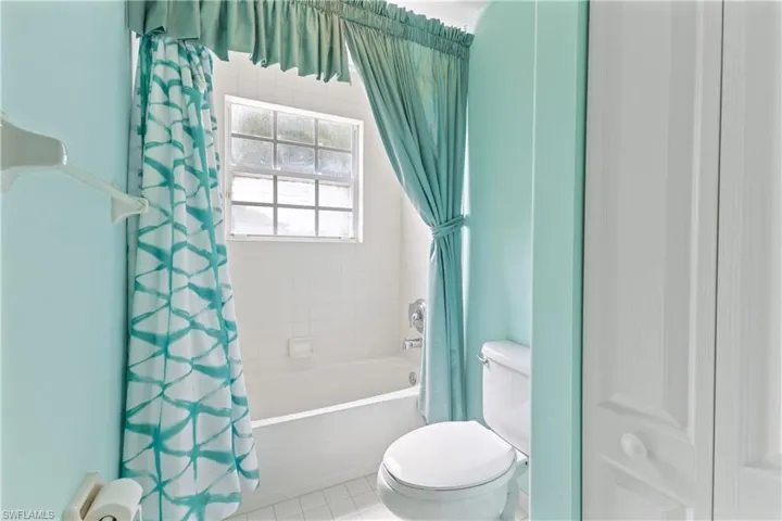 Bathroom with toilet, tile patterned floors, and shower / tub combo