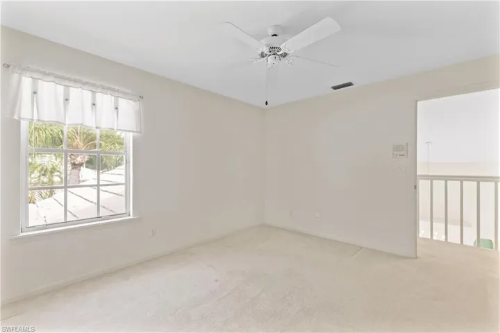 Unfurnished room with ceiling fan and light colored carpet