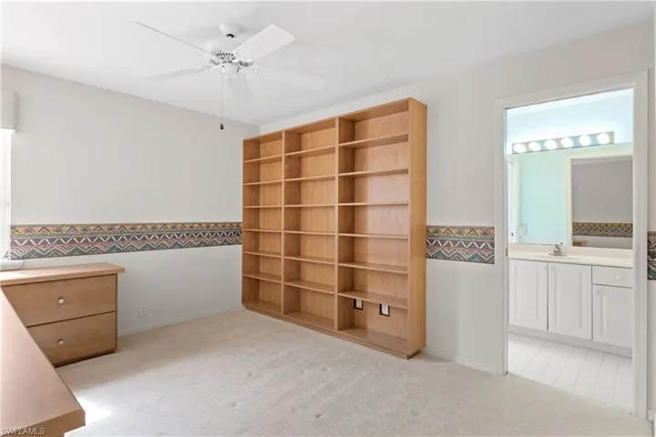 Unfurnished bedroom featuring sink, ceiling fan, connected bathroom, and light colored carpet