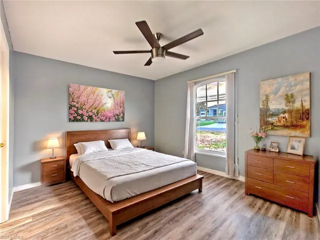 Bedroom with baseboards, a ceiling fan, and light wood-style flooring
