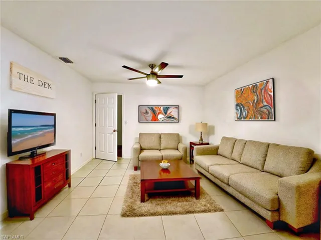 Tiled living room with baseboards, a ceiling fan, and visible vents
