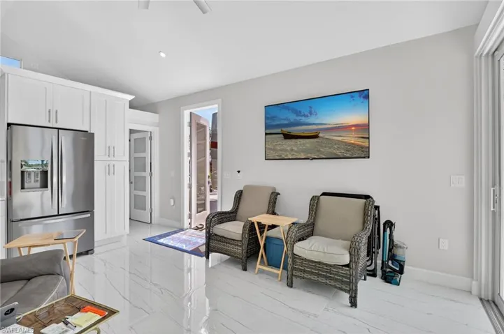 Sitting room with light marble finish floors and ceiling fan