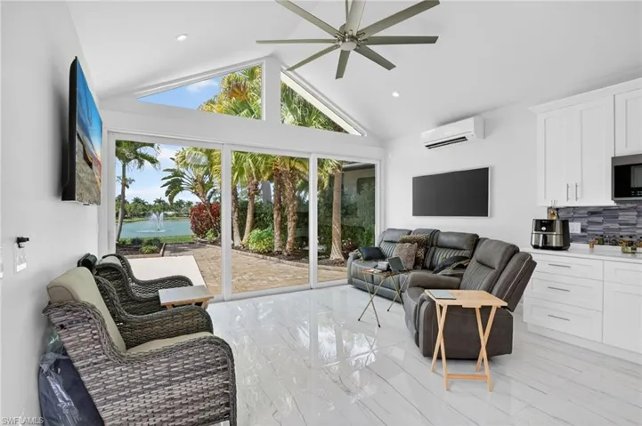 Living room with ceiling fan, plenty of natural light, a high ceiling, and recessed lighting