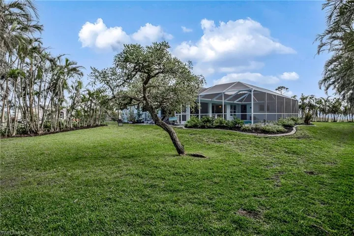 View of grassy yard featuring glass enclosure