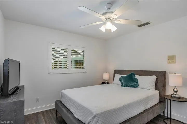 Bedroom with dark wood finished floors and ceiling fan