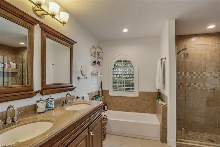 Full bathroom with tile patterned floors, a bath, a shower stall, double vanity, and recessed lighting