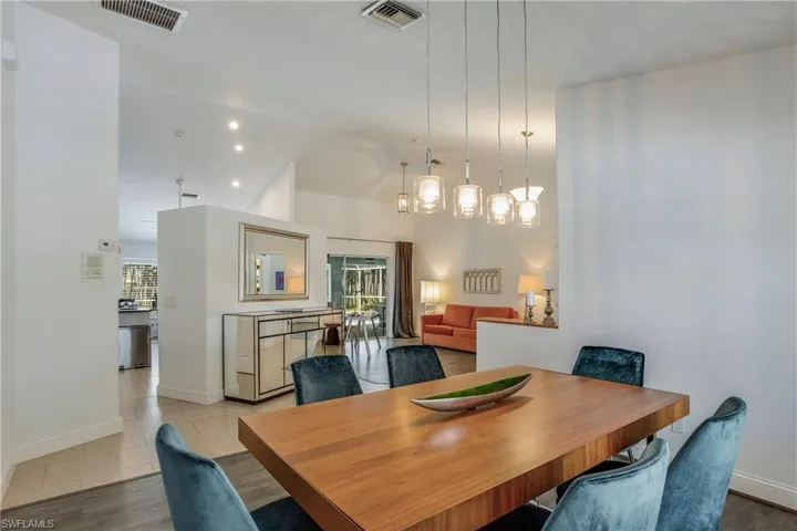 Dining room featuring plenty of natural light, lofted ceiling, and wood finished floors