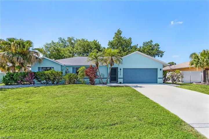 Light blue exterior with a dark blue garage door and a concrete driveway