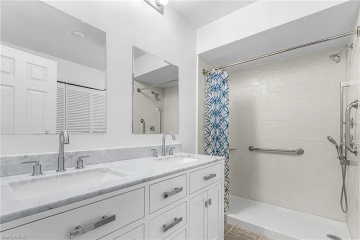 Dual vanity with integrated sinks, marble-finish countertop, and brushed nickel fixtures