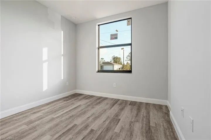 Spare room featuring light wood-style flooring and baseboards
