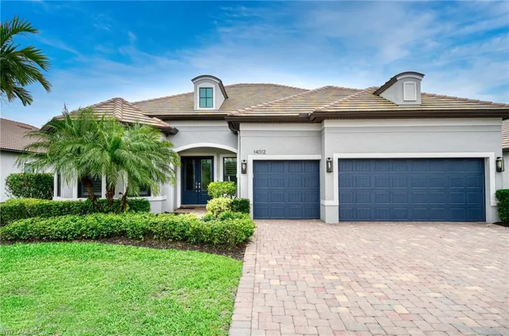 View of front of home with driveway, stucco siding, an attached garage, a tile roof, and french doors