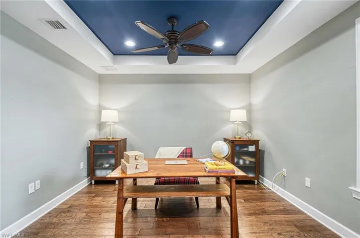 Dining area featuring a raised ceiling, hardwood / wood-style floors, an office area, ceiling fan, and recessed lighting