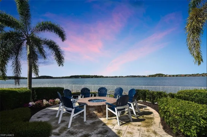 Patio terrace at dusk featuring a patio area, a water view, and a fire pit