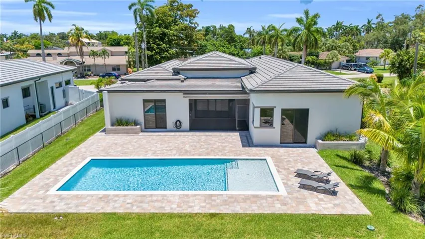 Rear view of house featuring a patio area and a fenced in pool