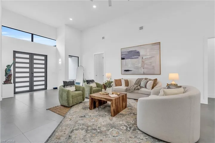 Living room featuring tile patterned flooring and a high ceiling