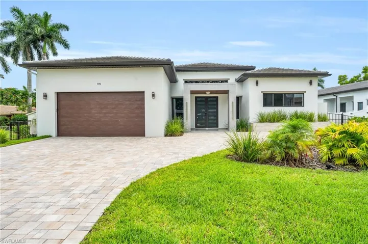 View of front of property with a garage and a front lawn