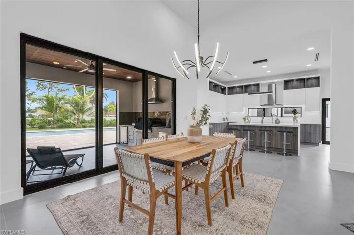Dining room featuring sink, a chandelier, and a high ceiling
