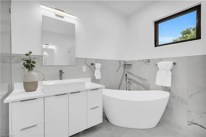 Bathroom featuring vanity, tile walls, and tile patterned floors