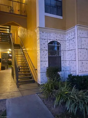 Entrance to property with stucco siding and a balcony