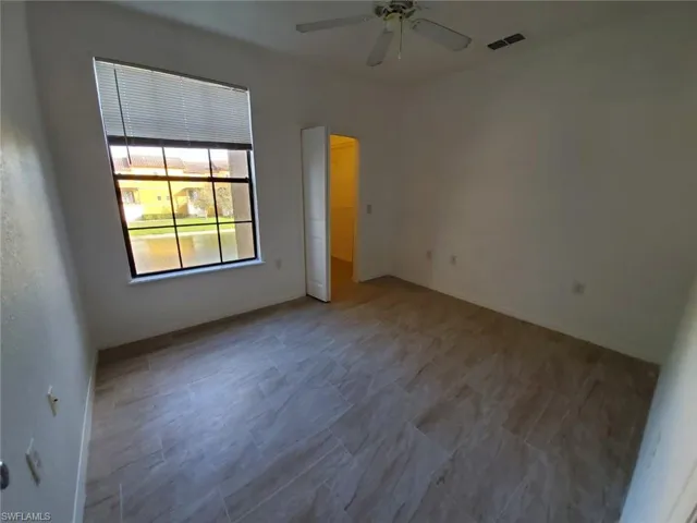 Spare room with ceiling fan and baseboards