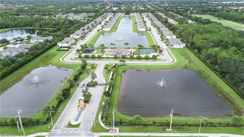 Aerial view of residential area featuring a large body of water and a tree filled landscape
