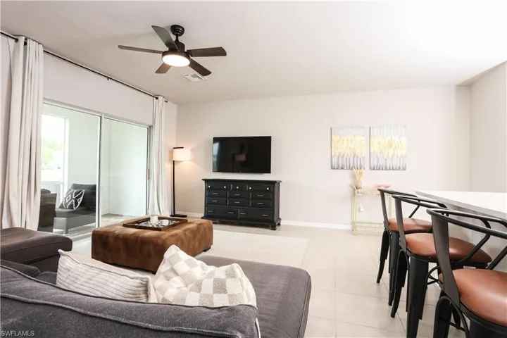 Living area with light tile patterned floors and ceiling fan