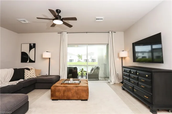 Living area featuring light tile patterned floors and ceiling fan