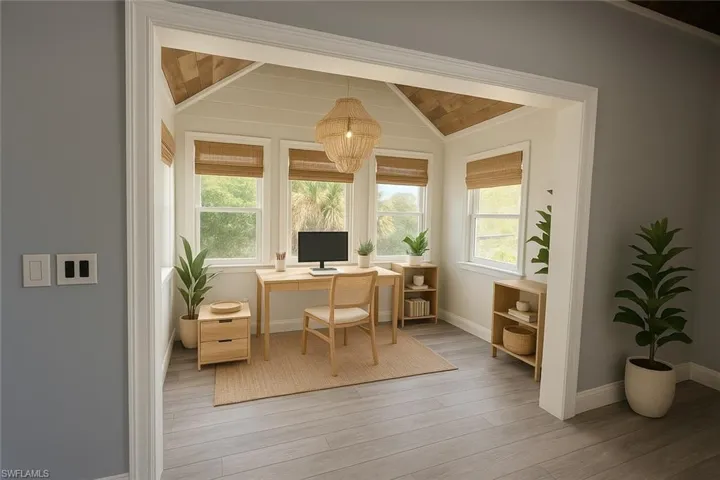 Office area with light wood-style floors, plenty of natural light, and lofted ceiling