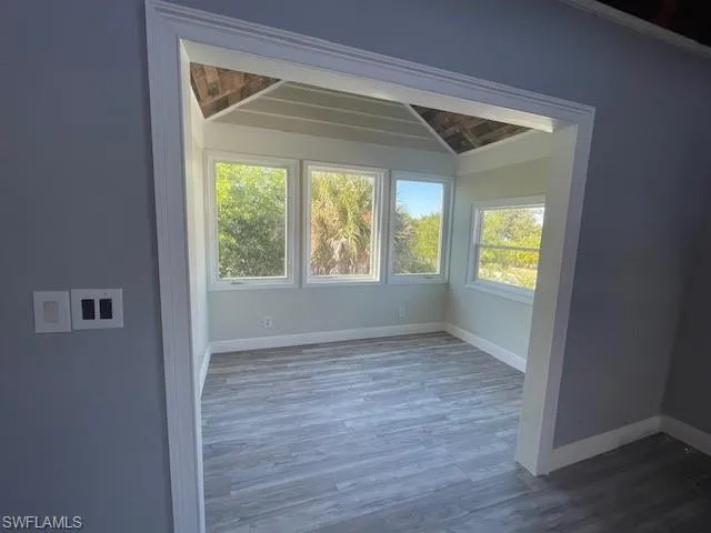 Spare room featuring dark wood finished floors and baseboards