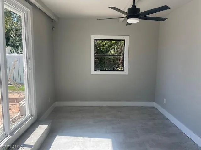 Empty room featuring baseboards and a ceiling fan