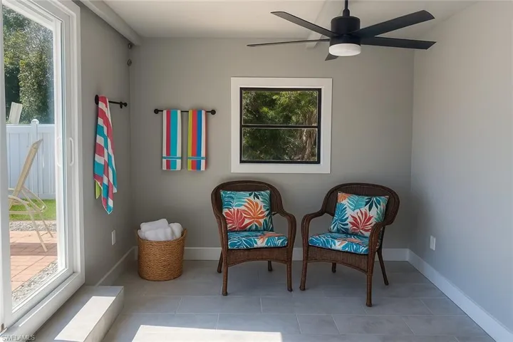 Living area featuring light tile patterned floors and ceiling fan