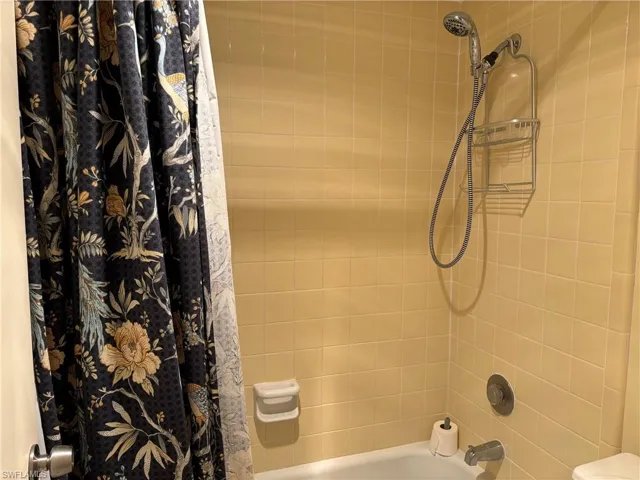 Bathroom featuring shower / tub combo with curtain