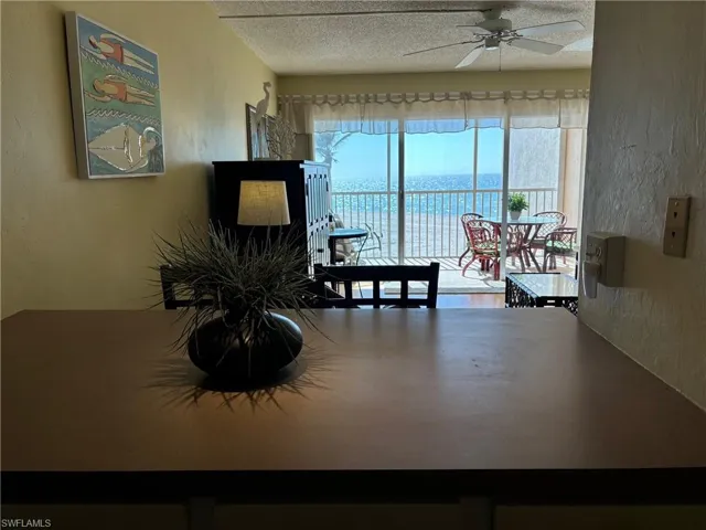 Dining space featuring a textured ceiling, a water view, and ceiling fan