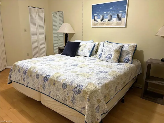 Bedroom with two closets and hardwood / wood-style flooring