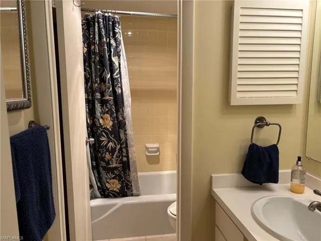 Full bathroom featuring shower / tub combo with curtain, vanity, and toilet