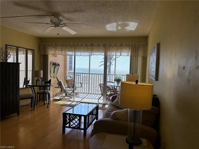 Living room with wood-type flooring, a water view, plenty of natural light, and ceiling fan