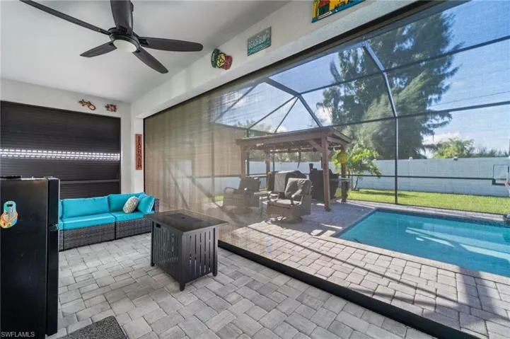 View of pool with an outdoor hangout area, glass enclosure, a patio, and a sunroom