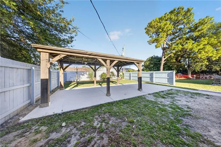 Expansive outdoor pavilion with a concrete pad and exposed wood beam construction, complemented by string lighting